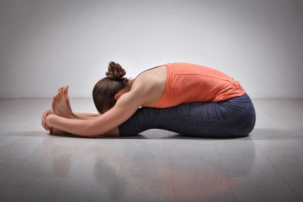 Tư thế gập lưng là bài tập yoga chữa thoát vị đĩa đệm đơn giản nhưng hiệu quả